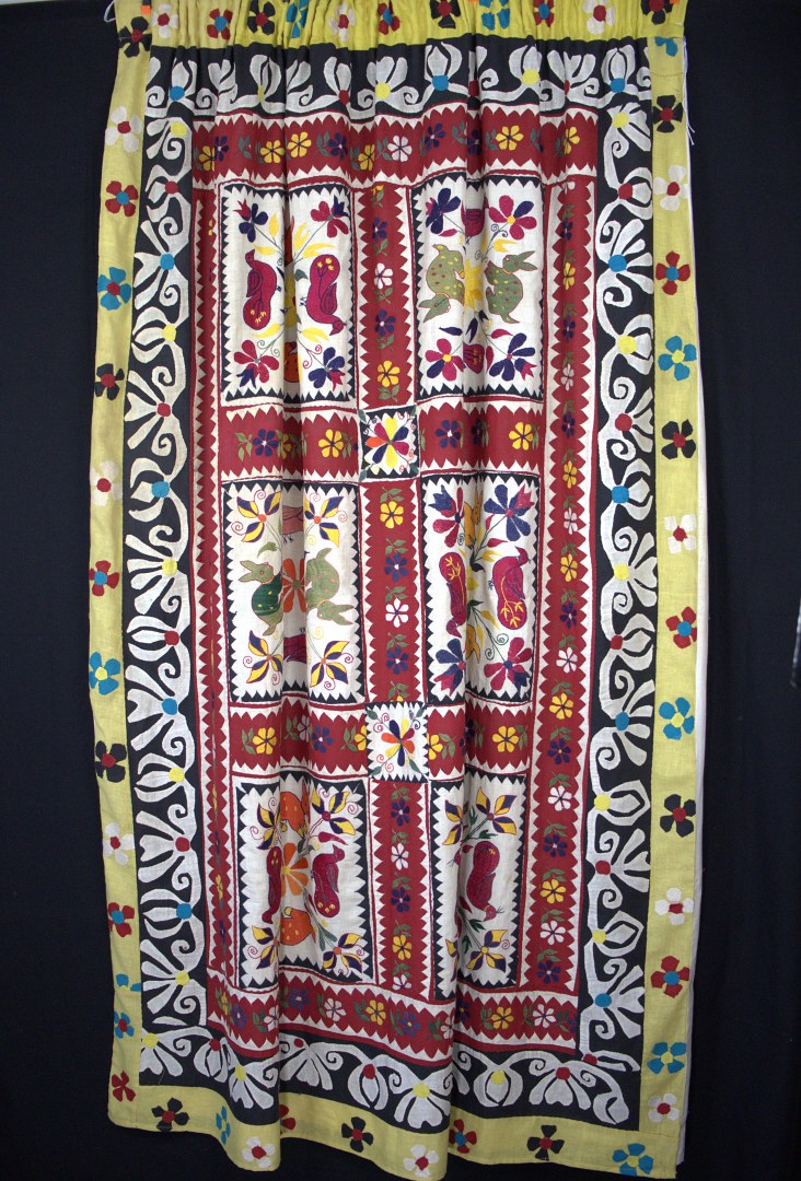 applique rabbits and ducks with embroidered flowers cover this curtain.