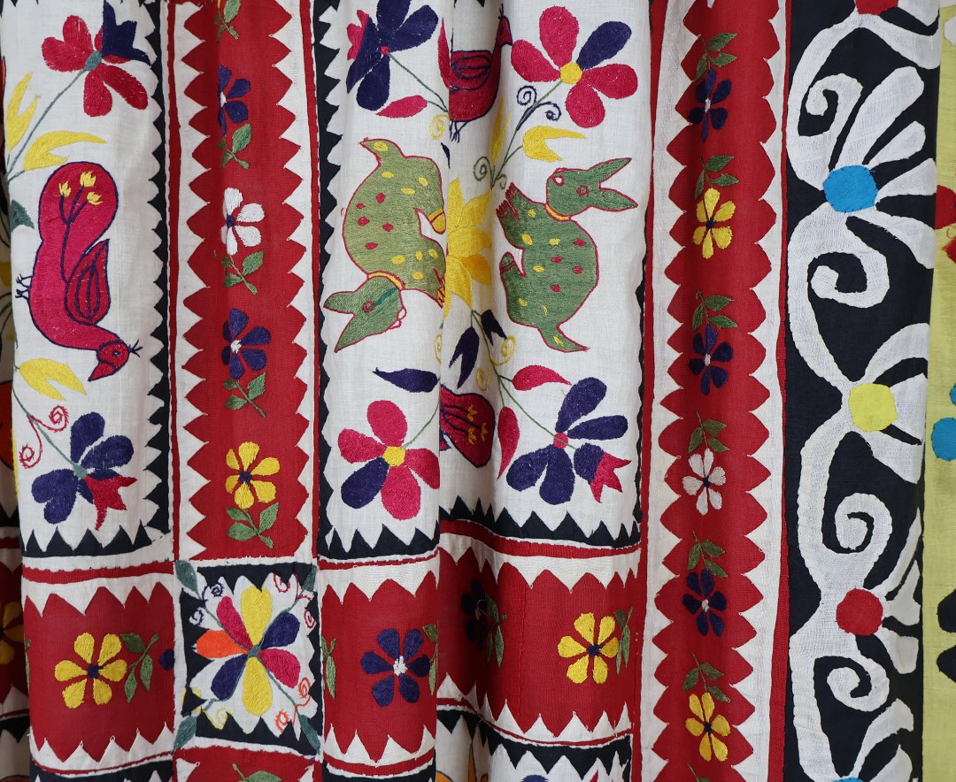 applique rabbits and ducks with embroidered flowers cover this curtain.