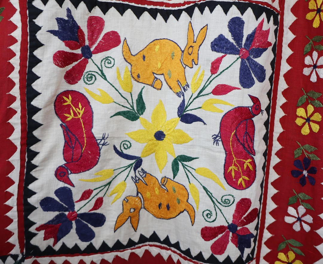 applique rabbits and ducks with embroidered flowers cover this curtain.