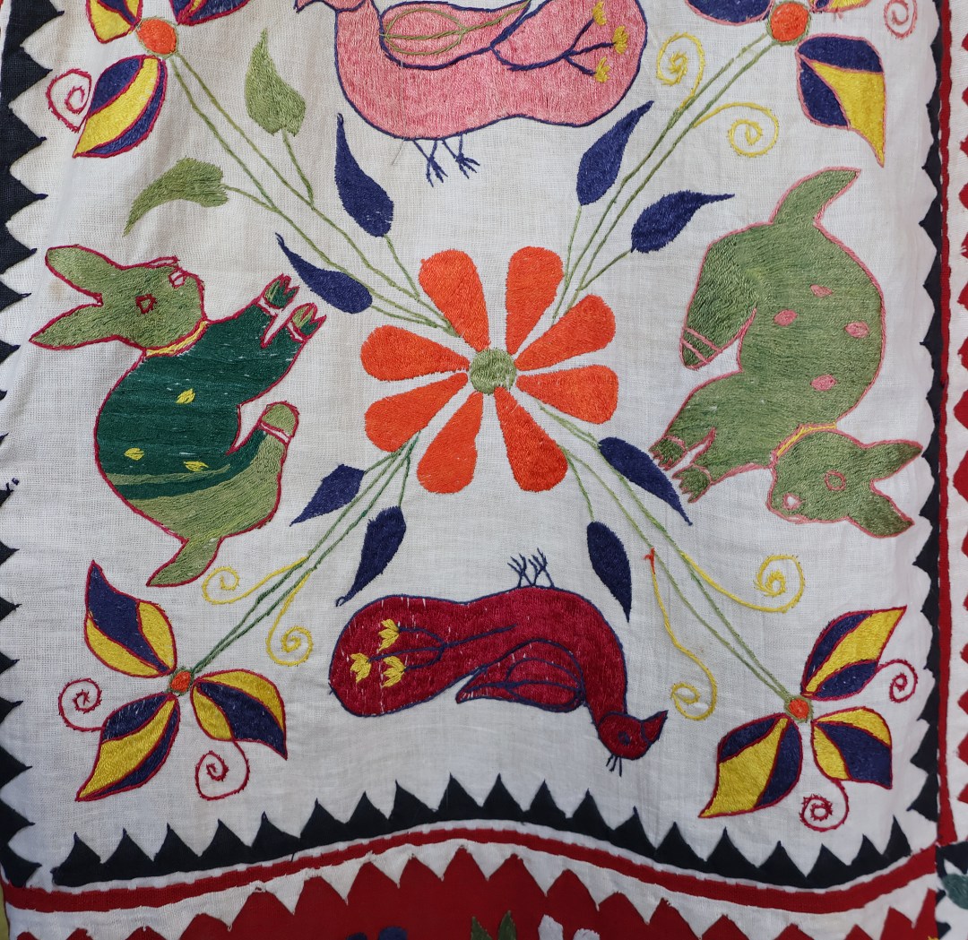 applique rabbits and ducks with embroidered flowers cover this curtain.