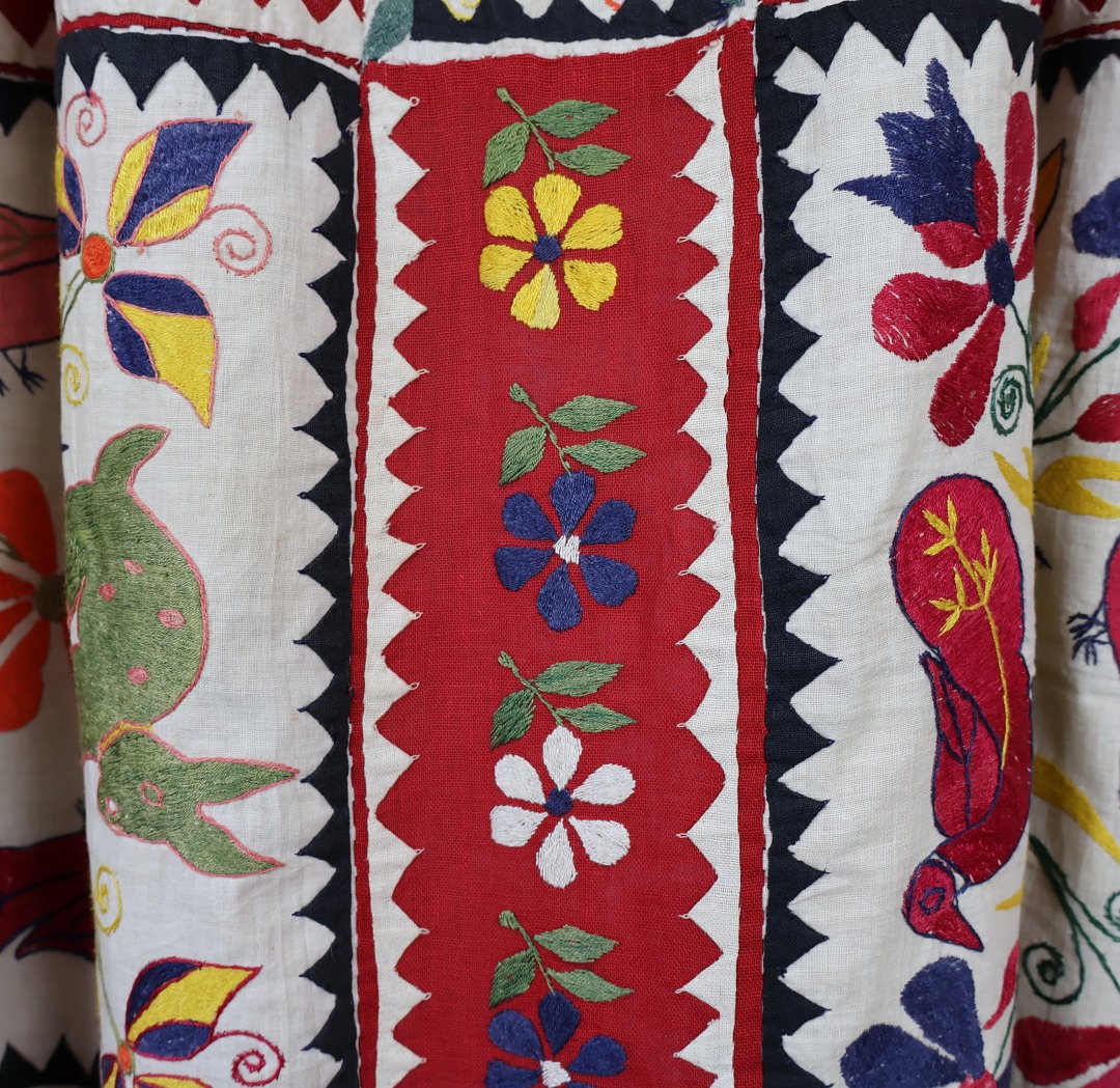 applique rabbits and ducks with embroidered flowers cover this curtain.