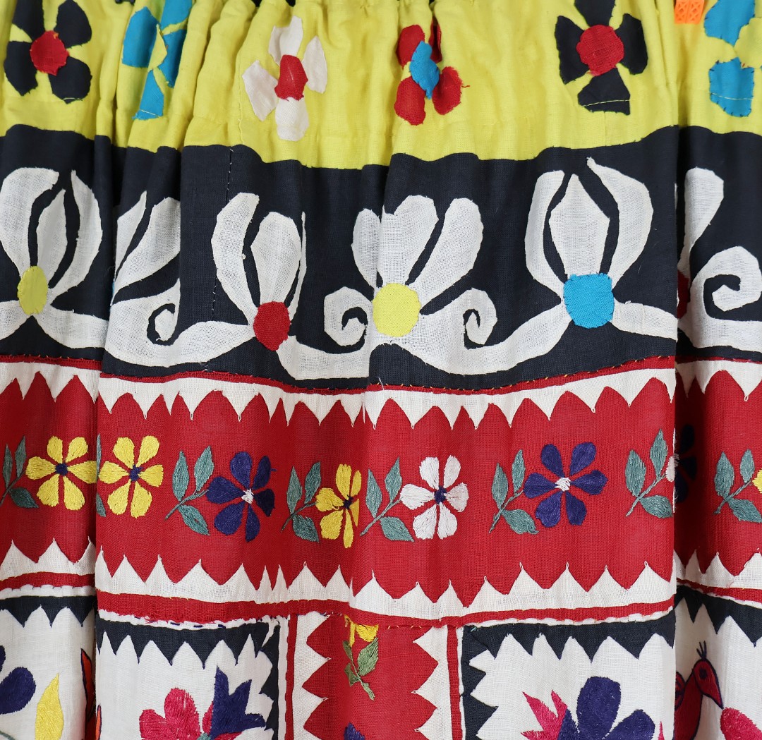 applique rabbits and ducks with embroidered flowers cover this curtain.