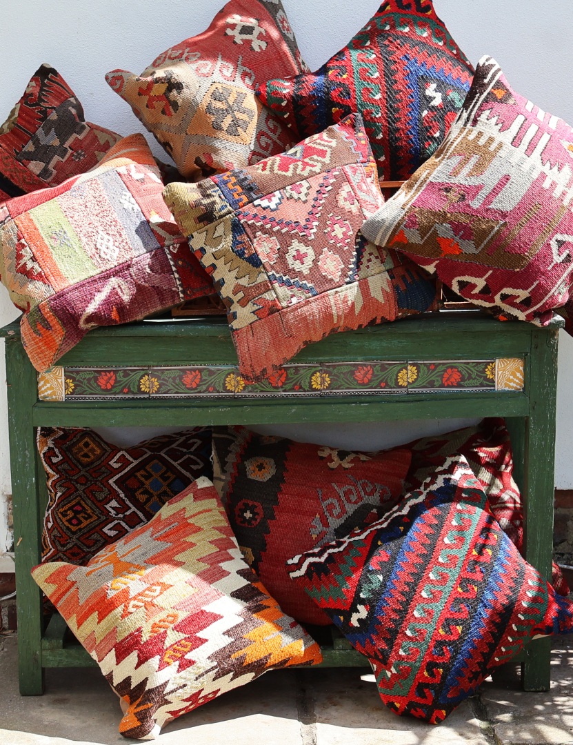 A number of colourful geometric design cushions.