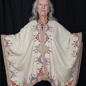 woman wearing embroidered poncho.