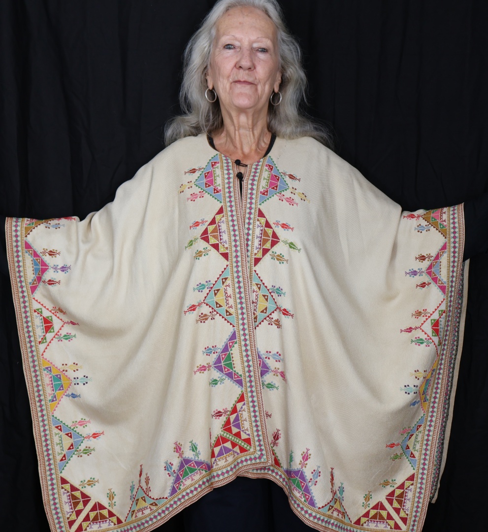 woman wearing embroidered poncho.