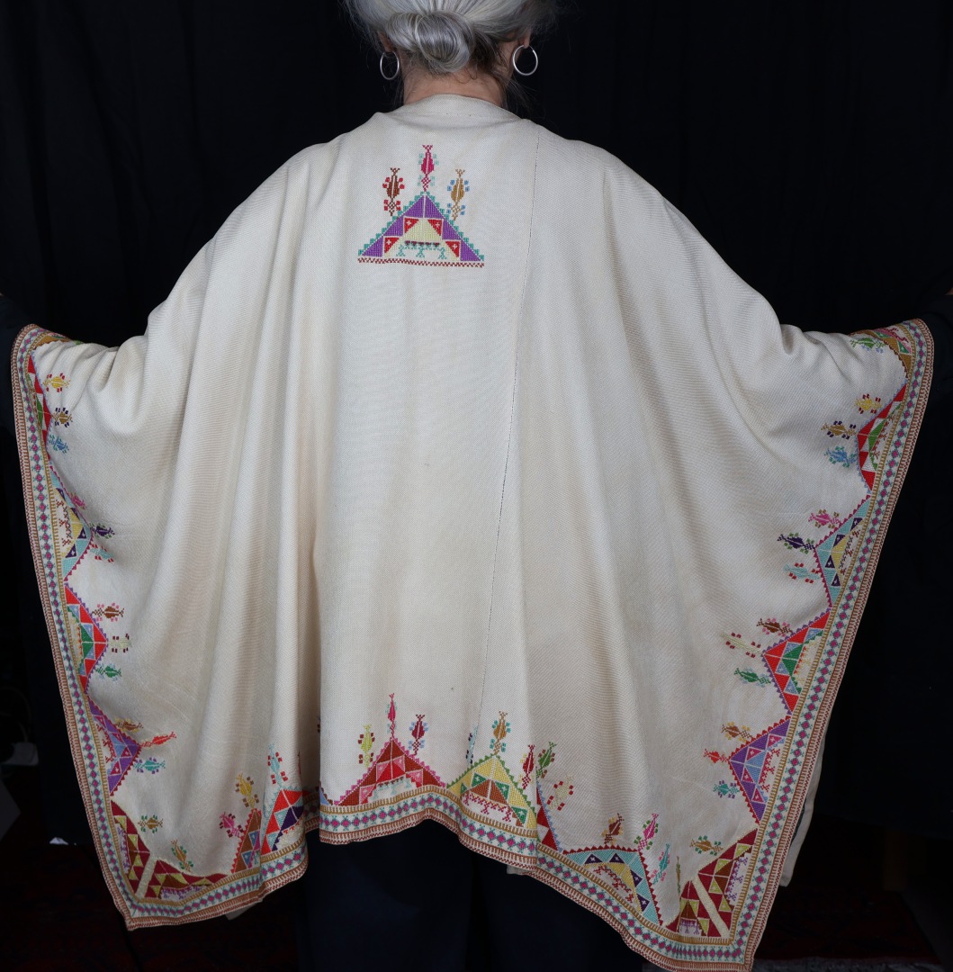 woman wearing embroidered poncho.
