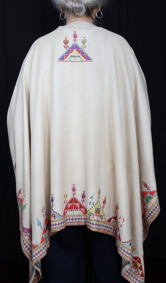 woman wearing embroidered poncho.